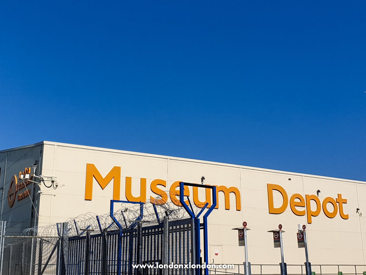 The Museum Depot sign in orange lettering on the depot's exterior wall against a clear blue sky