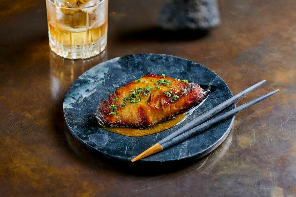 Black cod on a plate with chopsticks