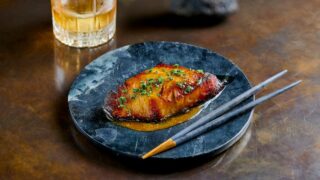 Black cod on a plate with chopsticks