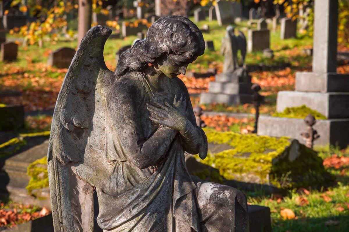 A weathered angel statue among the graves at Brompton Cemetery