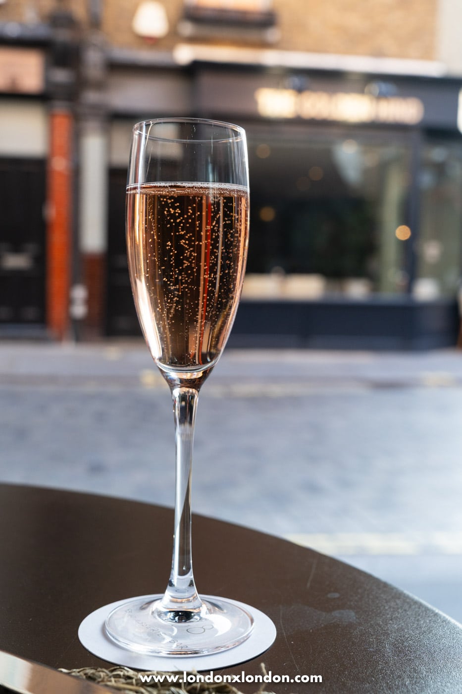 A waiter pouring a magnum of Chateau La Coste rose tableside at 108 Brasserie's La Terrasse on the Lane