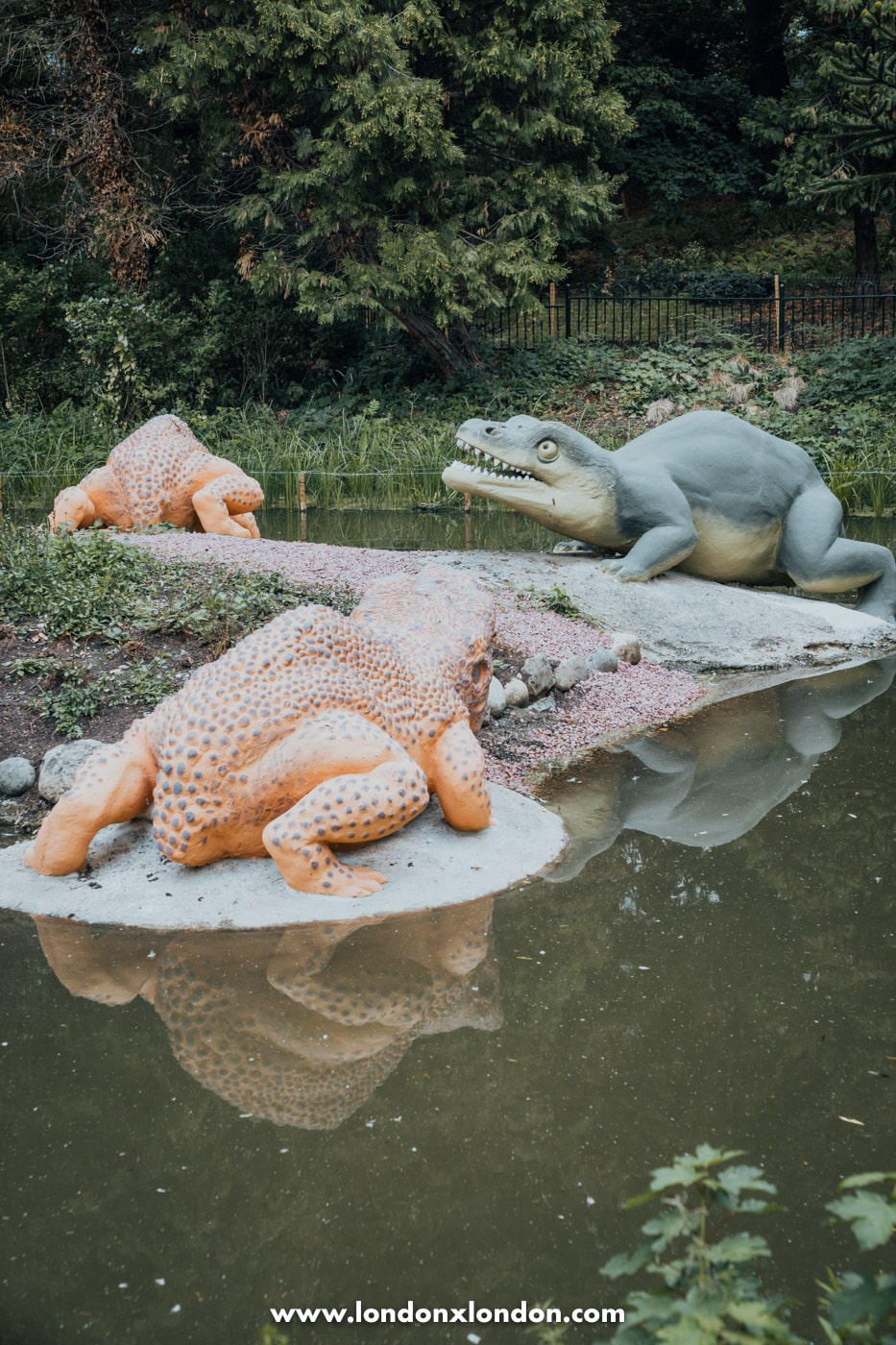 A Crystal Palace dinosaur sculpture repainted in bright orange after the 2026 restoration