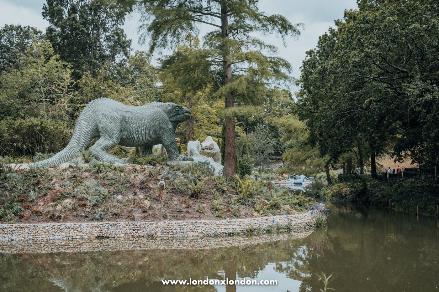 Restored dinosaur sculptures beside the lake in Crystal Palace Park