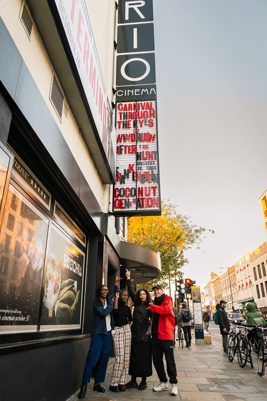 A group posing outside the Rio Cinema under its marquee sign