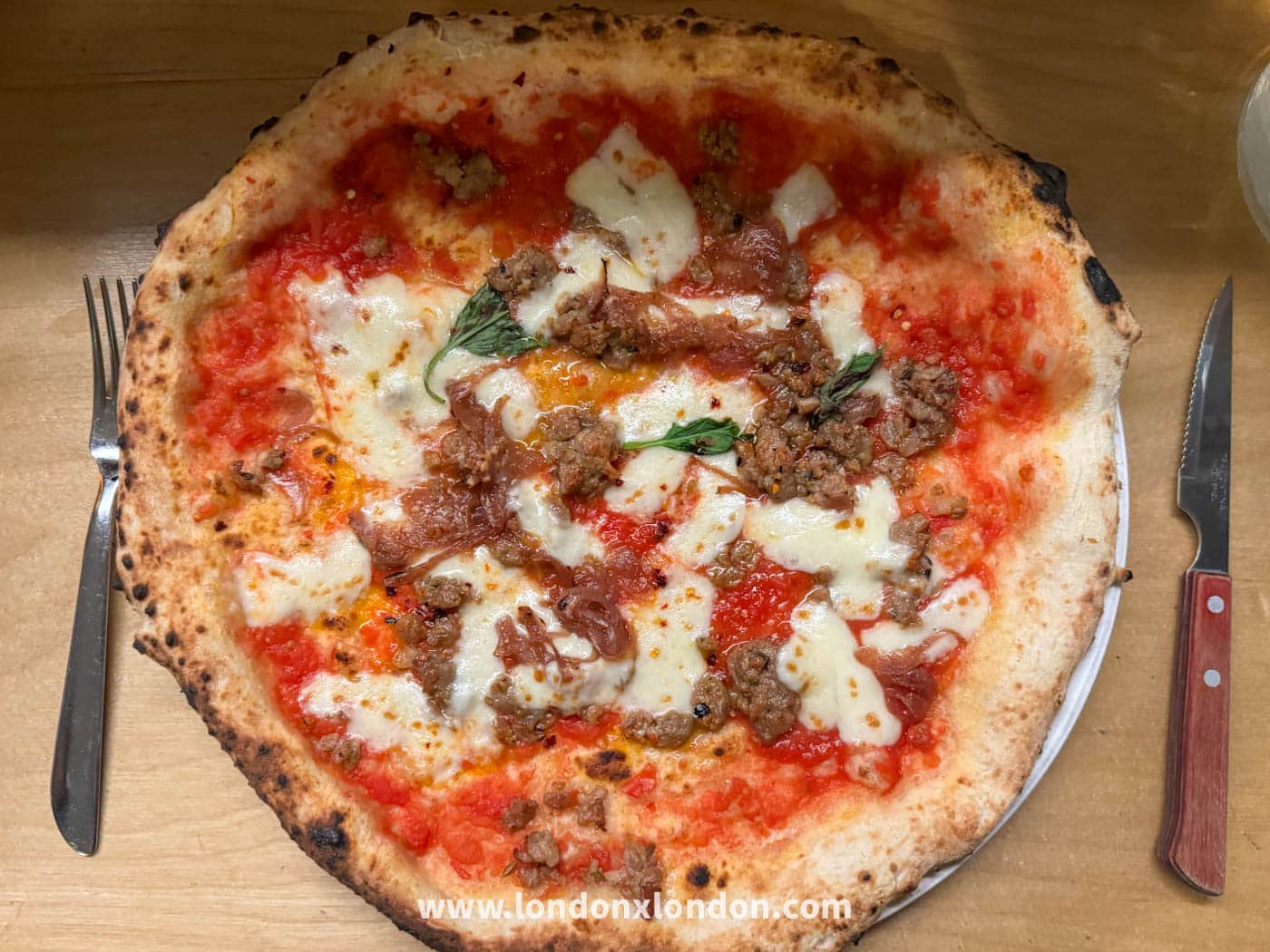 Inside Rudy's Pizza Napoletana on Wardour Street, Soho, with the restaurant's sign visible through the window