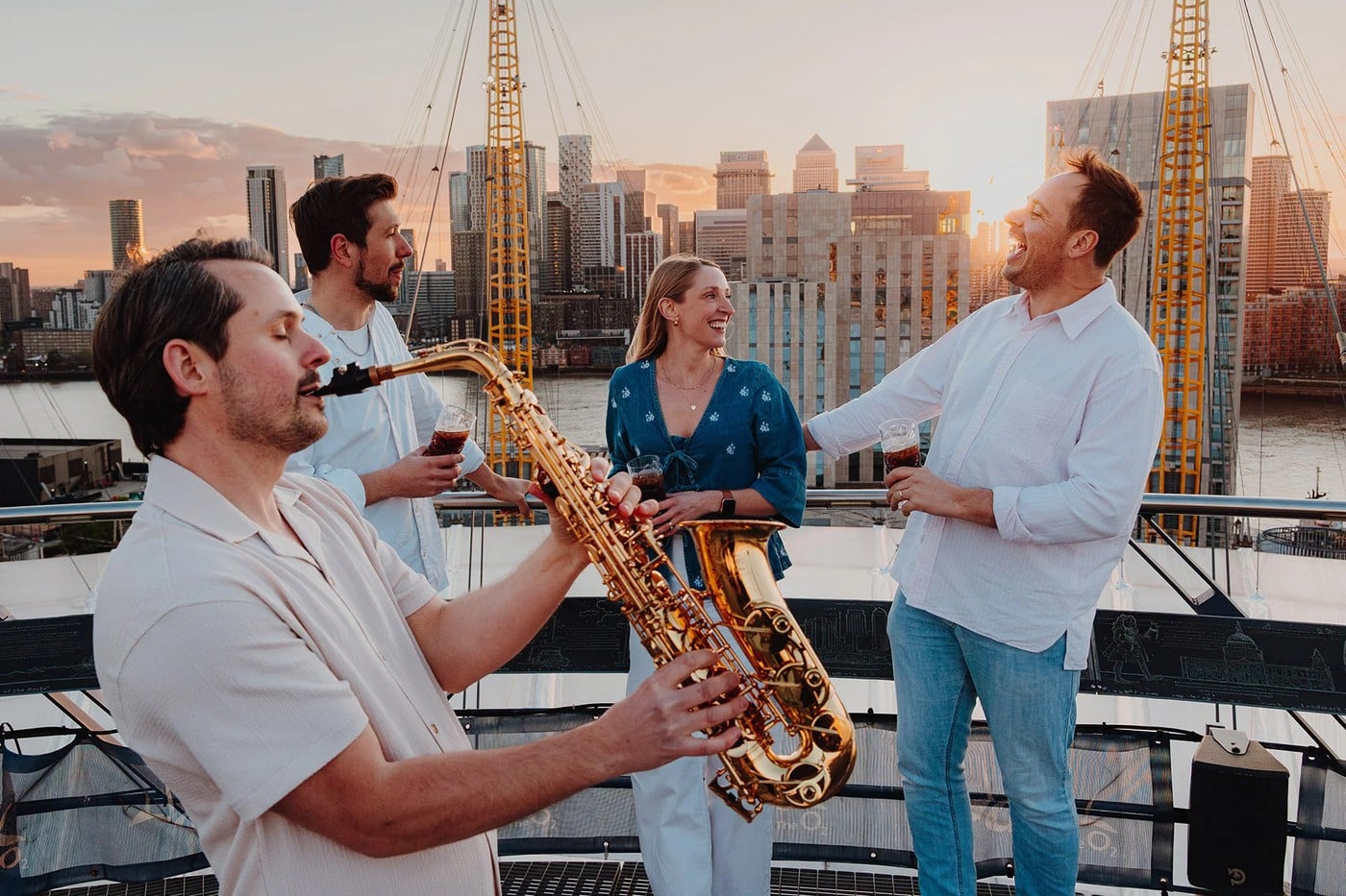 A saxophonist plays as climbers reach the summit during Up at The O2's Summer Sessions