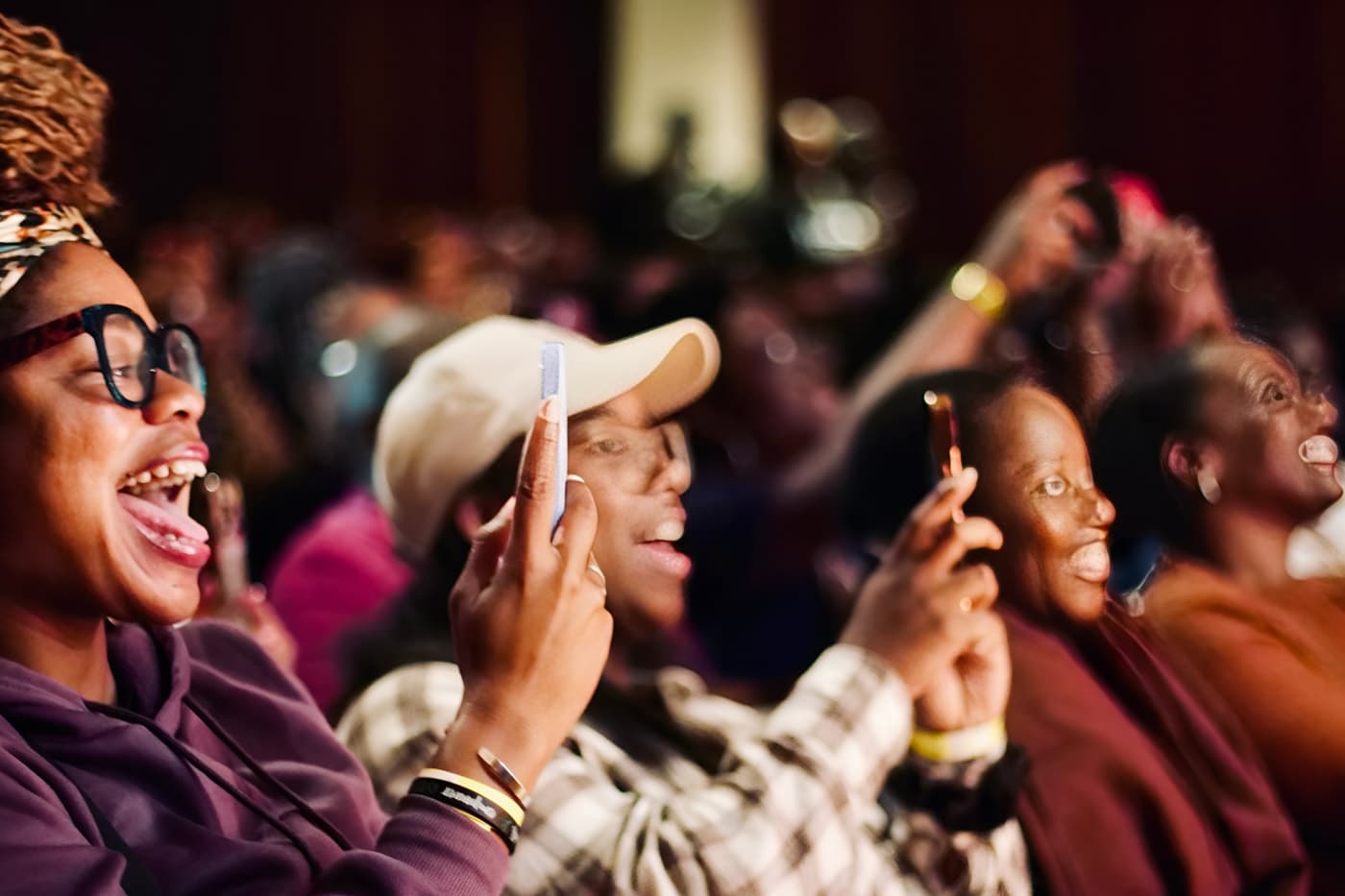 Audience members laughing and filming on their phones during a Black British Book Festival session