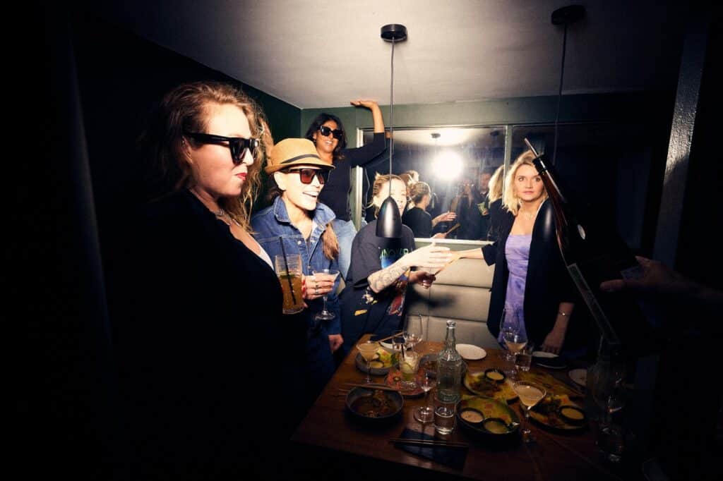 Guests with cocktails gathered around a laden table at the launch of Freak Scene's Monster Brunch in Balham.