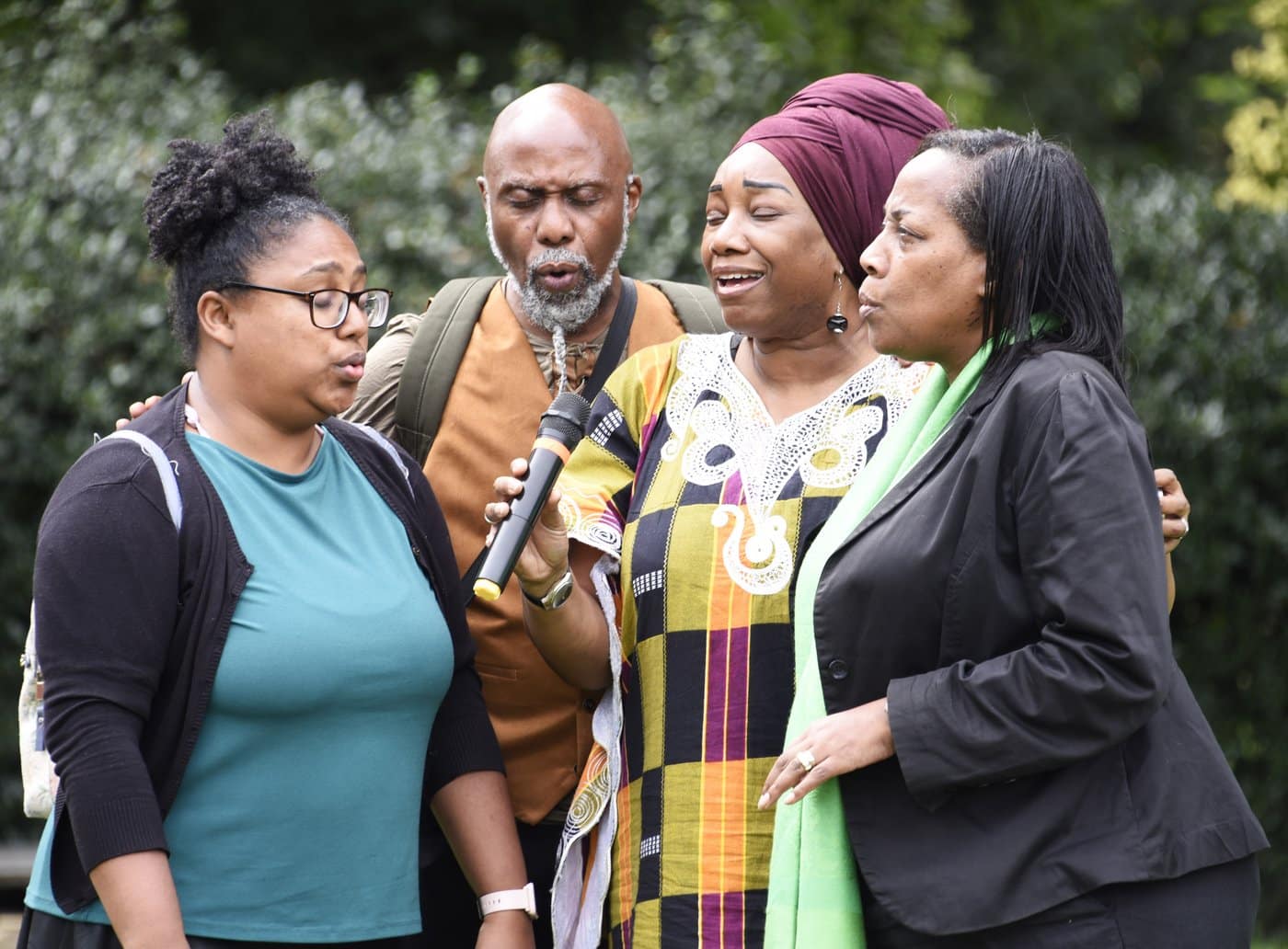 Four singers perform together outdoors as part of a participatory singing workshop