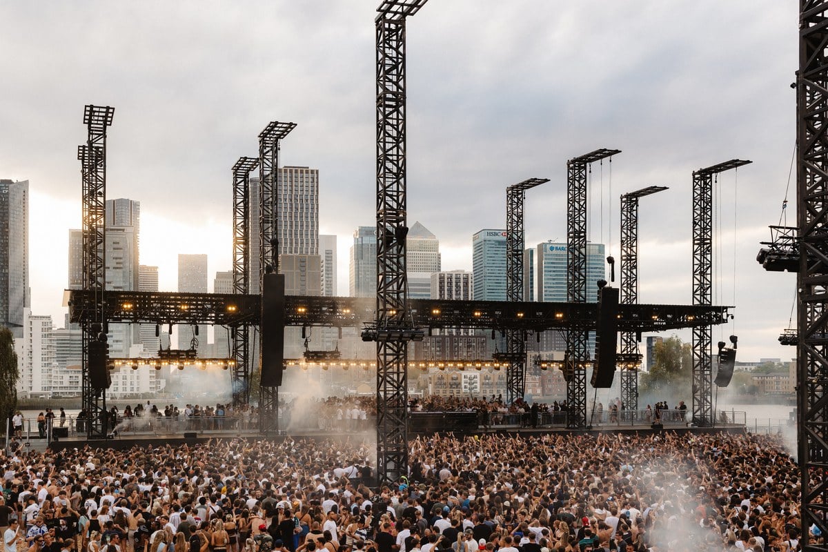 The crowd and stage at Magazine Open-Air, framed by the Canary Wharf skyline across the Thames