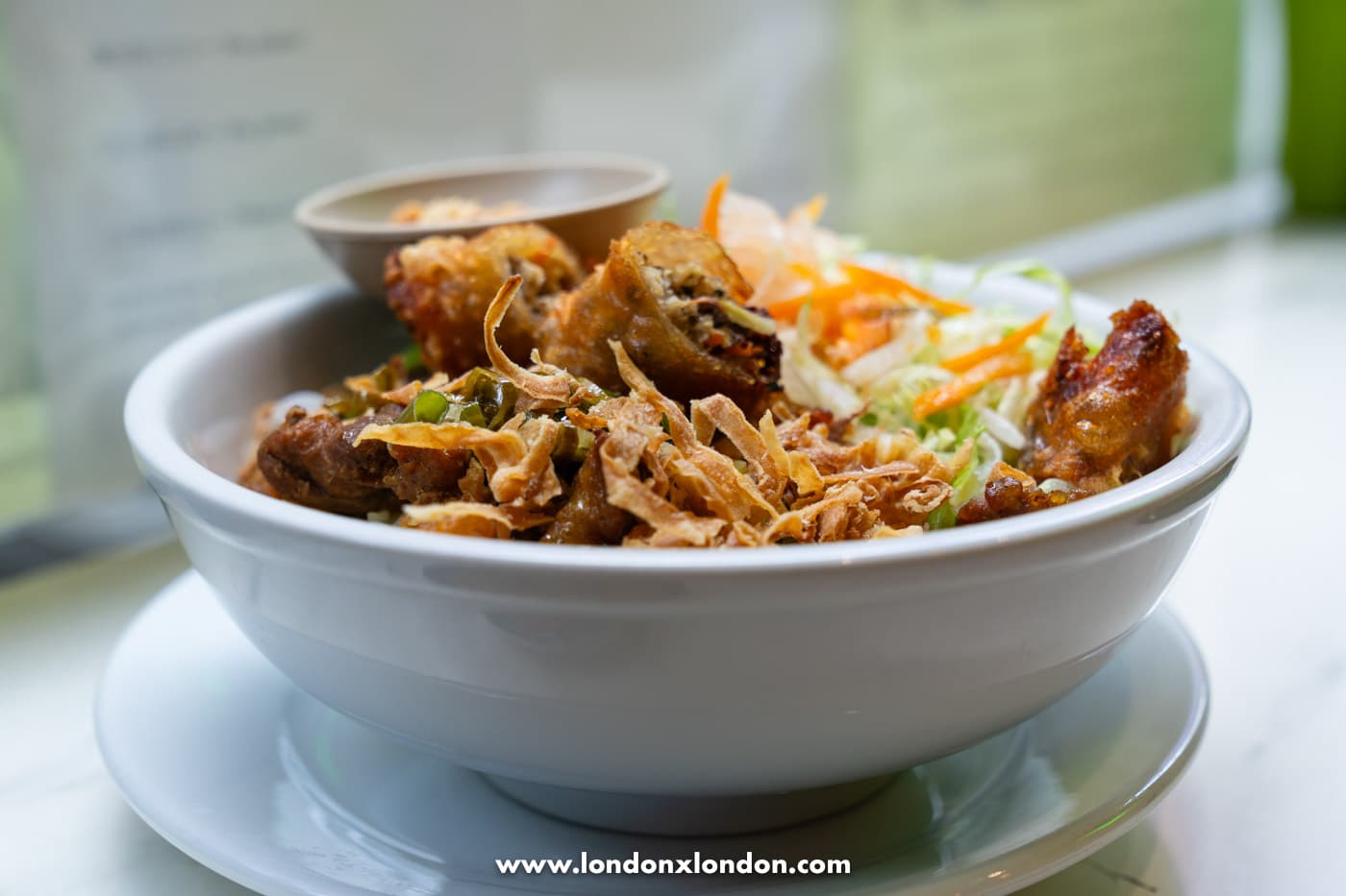 A bowl of bun cha gio at Pho Pham, vermicelli noodles topped with crispy pork spring rolls, grilled pork, pickled carrot and crispy shallots