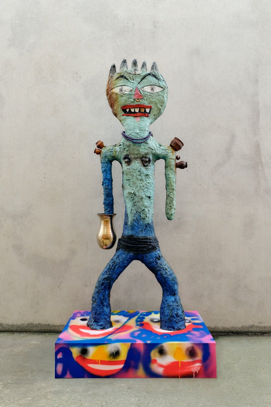 A colourful figurative sculpture by Ramesh Mario Nithiyendran on a spray-painted plinth