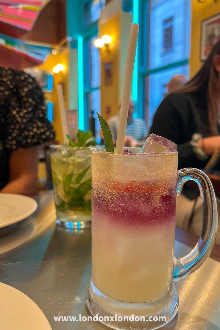 Cocktails served in a branded stein and a mojito at Speedboat Bar