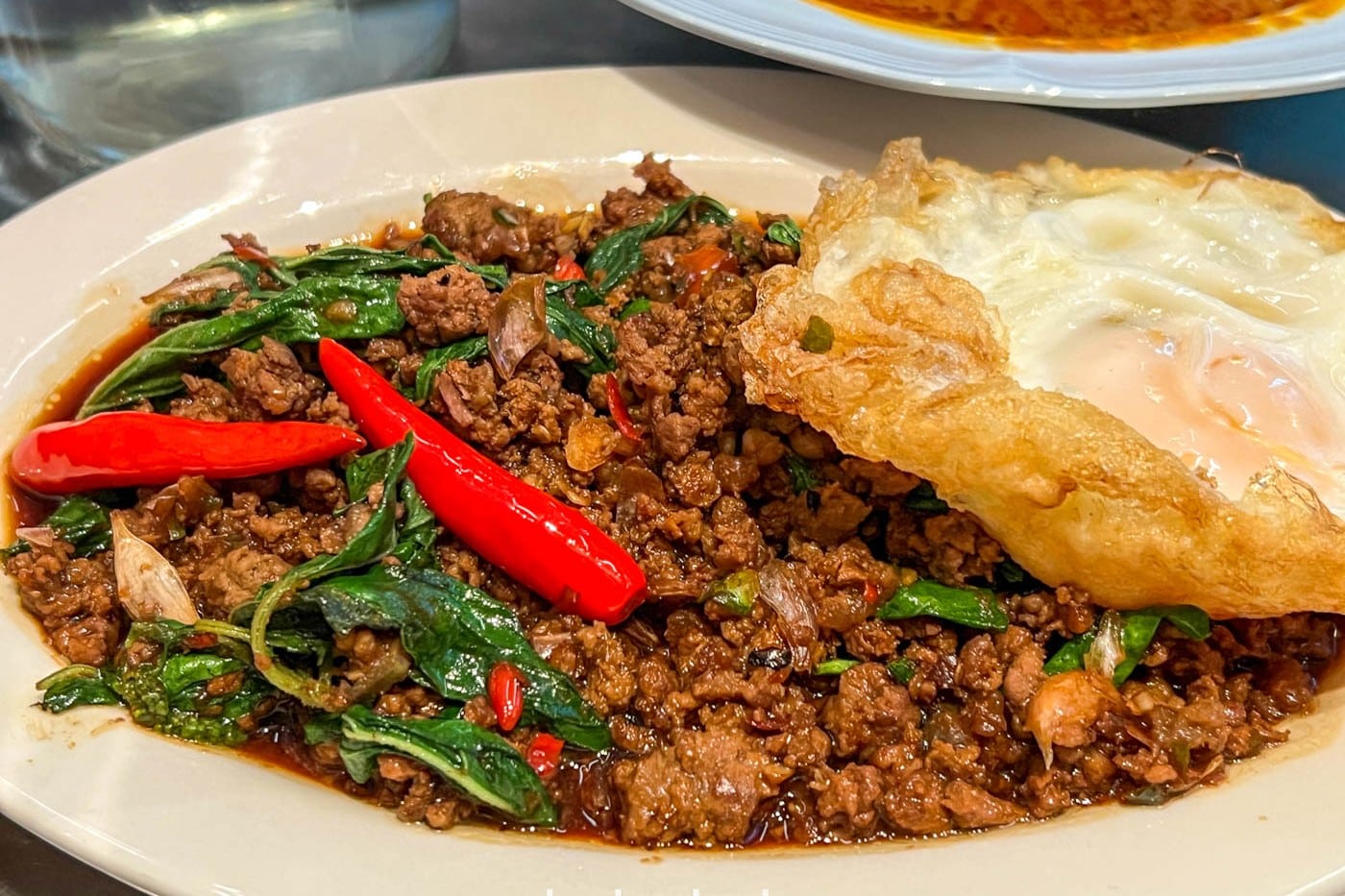 Speedboat Bar's pad kra pao, minced beef with holy basil, served with crispy pork skin and a fried egg