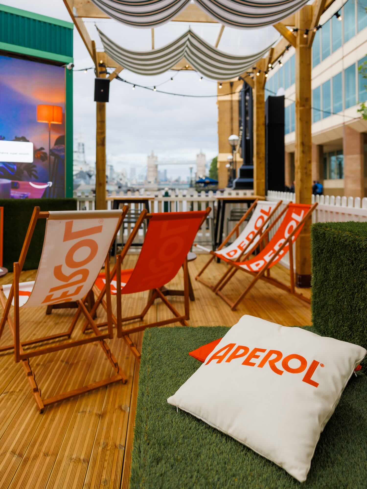 Deckchairs and cushions facing the screen at The Clubhouse, with Tower Bridge in the background