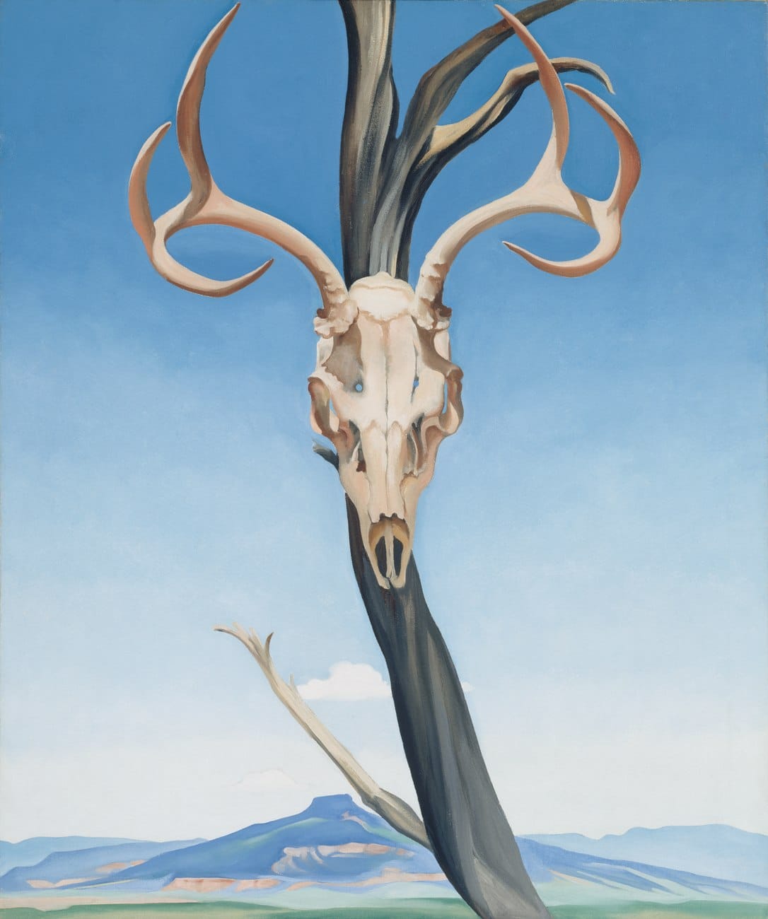Georgia O'Keeffe's painting Deer's Skull with Pedernal, a deer skull with wide antlers hung on a dead tree against a flat blue sky, with the flat-topped Cerro Pedernal in the distance
